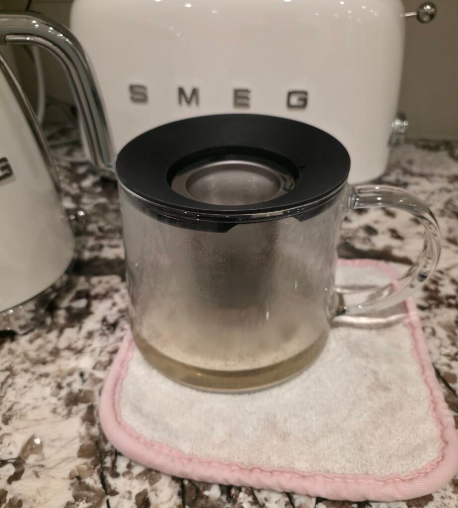 IKEA RIKLIG glass teapot with black plastic lid and stainless steel infuser on a kitchen counter